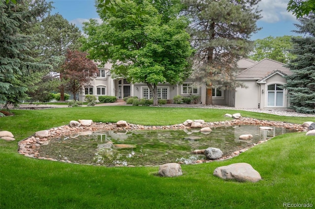 7 Mockingbird Ln, Cherry Hills Village, CO 80113 - view of front of home with a garden pond, a front lawn, stucco siding, and a tile roof