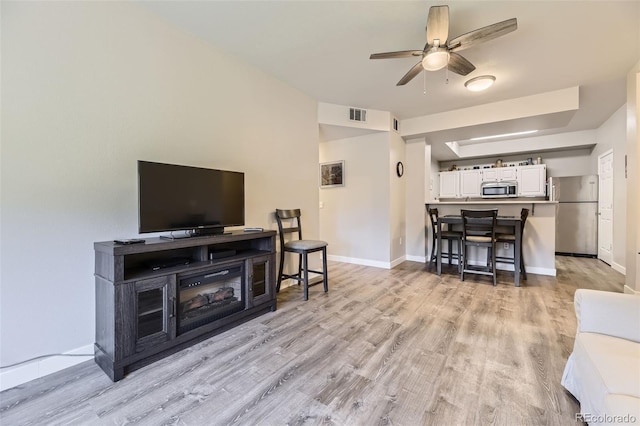 12818 Ironstone Way Unit 101, Parker, CO 80134 - living area with a ceiling fan, light wood-style floors, and baseboards