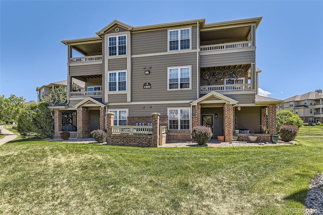 12818 Ironstone Way Unit 101, Parker, CO 80134 - view of front facade with brick siding, a balcony, and a front lawn