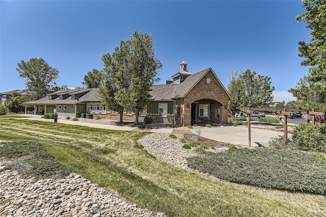 12818 Ironstone Way Unit 101, Parker, CO 80134 - rear view of house featuring brick siding, a lawn, and roof with shingles