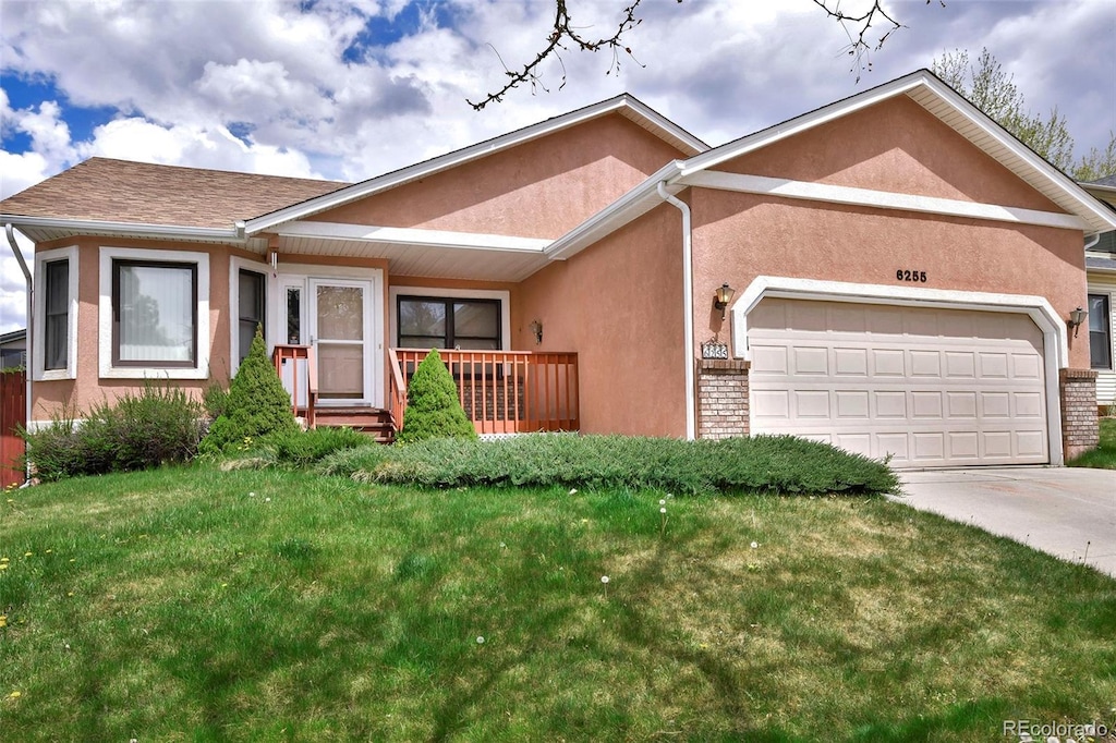 6255 Northwind Dr, Colorado Springs, CO 80918 - view of front of house with an attached garage, stucco siding, concrete driveway, a front yard, and brick siding