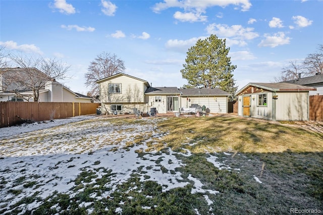 snow covered property with a yard and an outdoor structure