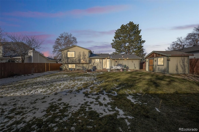 back house at dusk featuring a yard