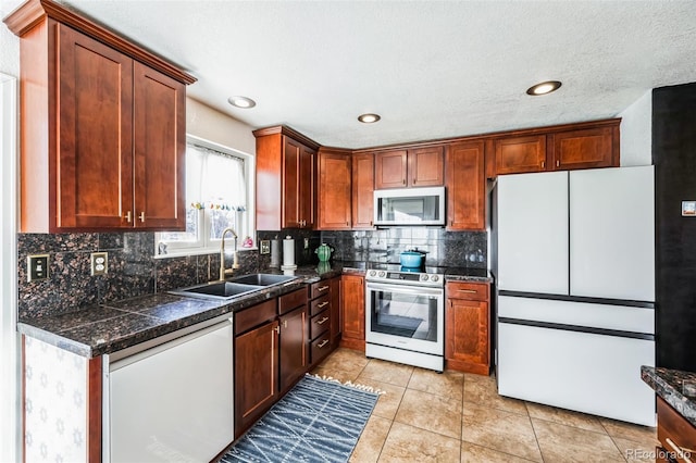 kitchen featuring sink, white appliances, decorative backsplash, and light tile patterned floors