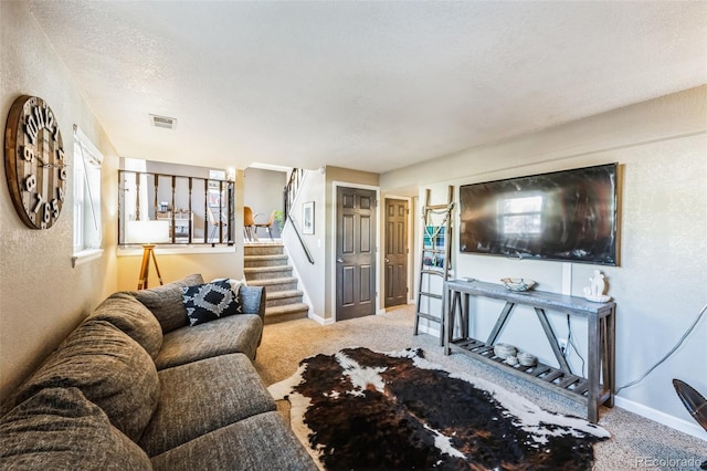 carpeted living room featuring a textured ceiling