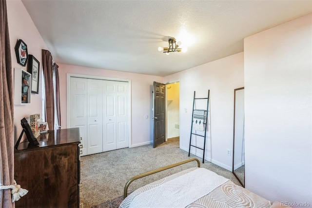 bedroom featuring a closet, a textured ceiling, and light colored carpet