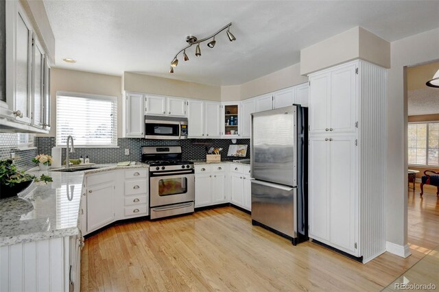 kitchen featuring white cabinetry, stainless steel appliances, and a healthy amount of sunlight