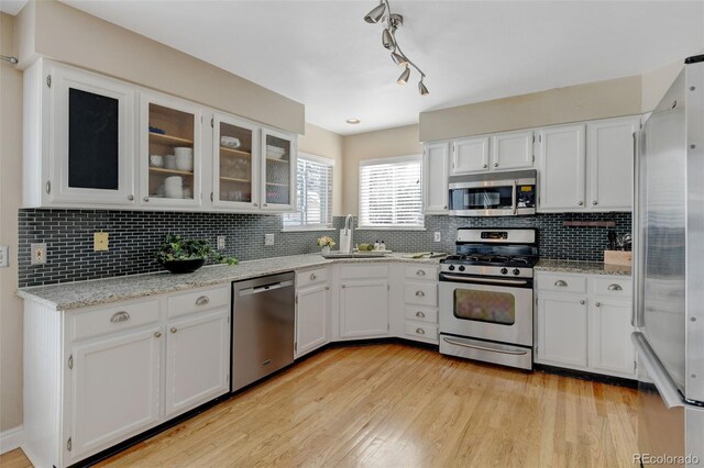 kitchen featuring white cabinetry, appliances with stainless steel finishes, sink, and backsplash