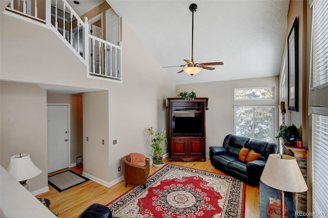 living room featuring ceiling fan, wood-type flooring, and high vaulted ceiling