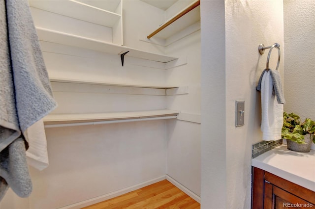 walk in closet with light wood-type flooring