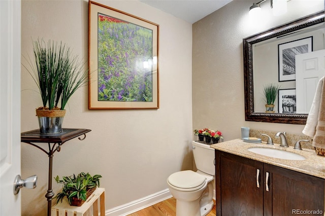 bathroom with vanity, hardwood / wood-style flooring, and toilet