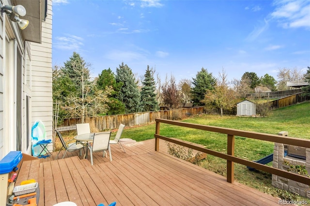 wooden deck featuring a shed and a lawn