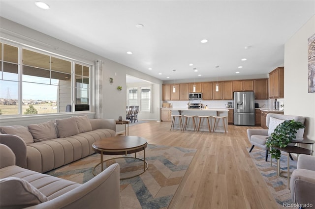 living area with recessed lighting and light wood-style flooring
