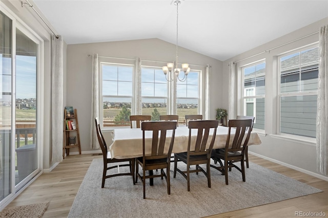 dining area featuring an inviting chandelier, baseboards, vaulted ceiling, and light wood-type flooring