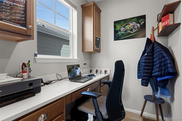 home office featuring baseboards, a wealth of natural light, and built in study area