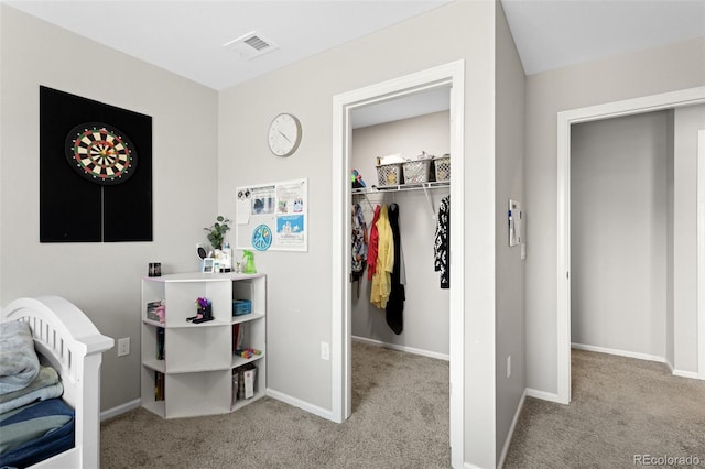 bedroom with carpet floors, visible vents, a closet, baseboards, and a walk in closet