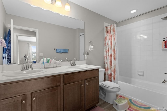 bathroom featuring double vanity, toilet, shower / bath combination with curtain, and a sink