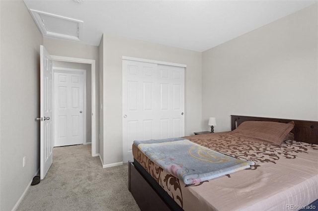 carpeted bedroom featuring baseboards, attic access, and a closet