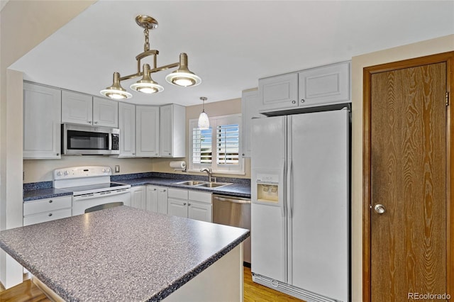 1982 S Truckee St, Aurora, CO 80013 - kitchen with stainless steel appliances, dark countertops, pendant lighting, a center island, and light wood-style floors