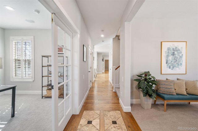 hall with recessed lighting, stairway, baseboards, and wood finished floors