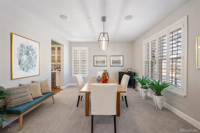 dining room with beverage cooler, carpet, and baseboards