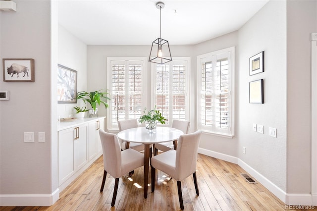 dining area featuring a wealth of natural light, baseboards, and light wood finished floors