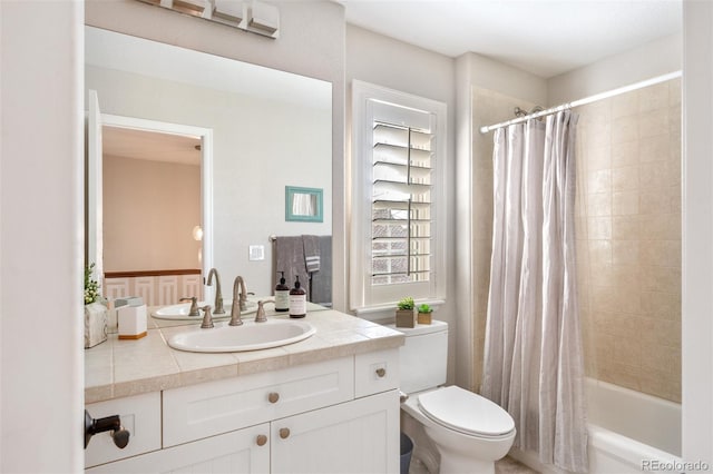 bathroom featuring toilet, shower / tub combo with curtain, and vanity