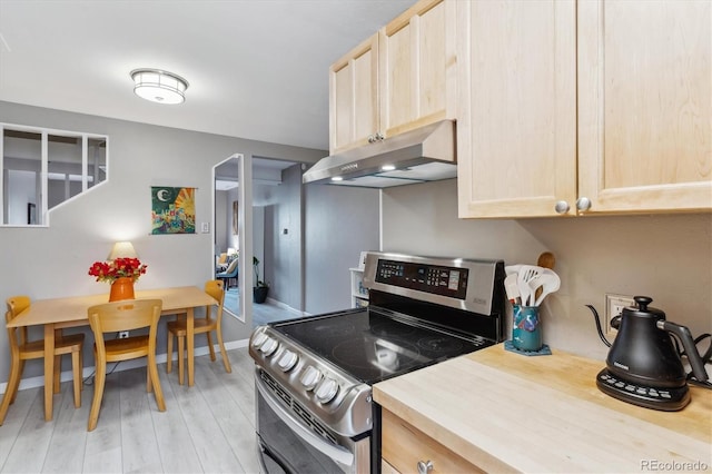 kitchen featuring light brown cabinets, light wood-style flooring, under cabinet range hood, electric stove, and light countertops