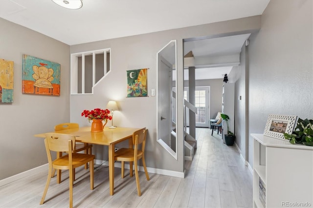 dining area featuring light wood-type flooring and baseboards