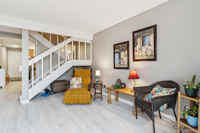 living area featuring stairs, wood finished floors, and baseboards