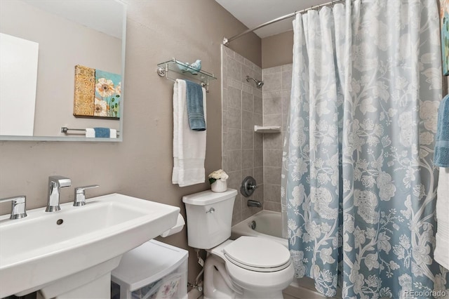 bathroom featuring toilet, shower / bath combo with shower curtain, and a sink