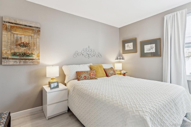 bedroom with wood finished floors and baseboards