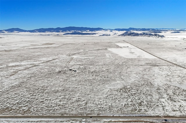 snowy aerial view with a mountain view