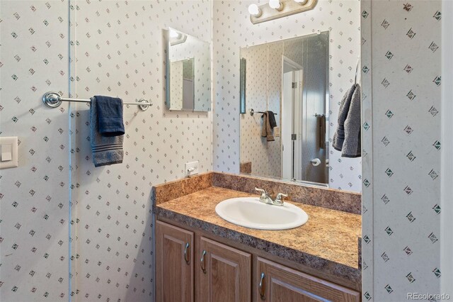 bathroom with vanity and wallpapered walls