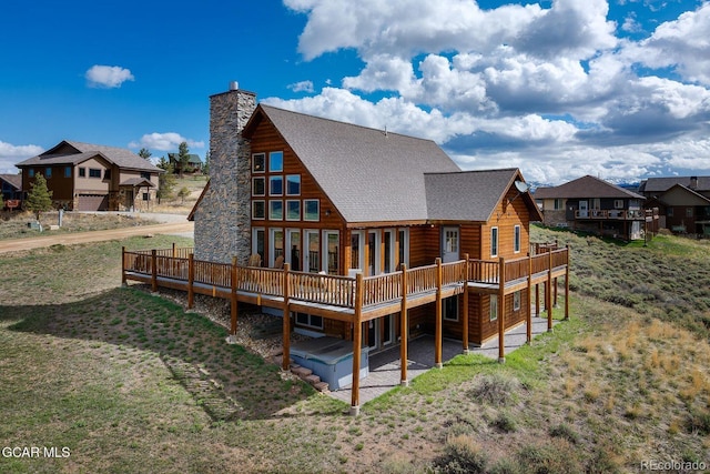 62 897, Grand Lake, CO 80447 - rear view of house with a wooden deck, a shingled roof, a chimney, a yard, and a patio area