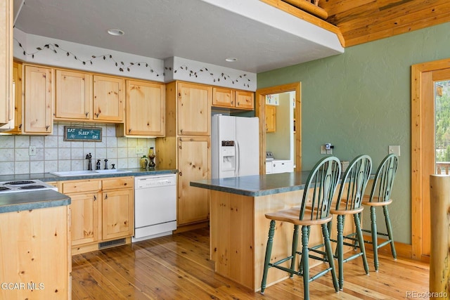 62 897, Grand Lake, CO 80447 - kitchen with white appliances, light brown cabinetry, dark countertops, a textured wall, and washer / dryer