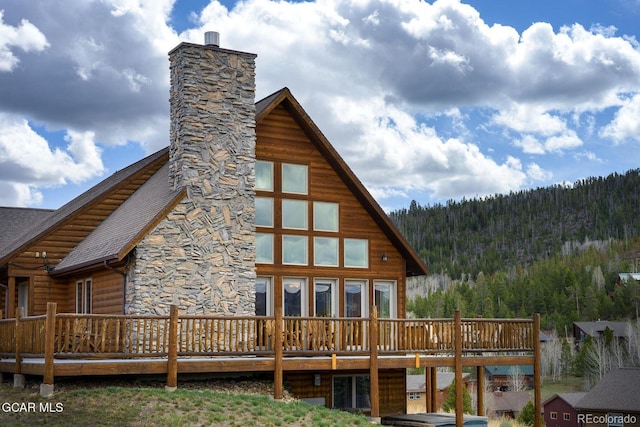 62 897, Grand Lake, CO 80447 - back of house with a wooden deck, a forest view, a chimney, and a shingled roof