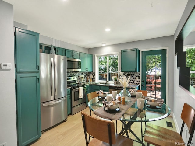 453 Arden Cir, Highlands Ranch, CO 80126 - kitchen featuring stainless steel appliances, green cabinetry, decorative backsplash, light wood-style flooring, and recessed lighting