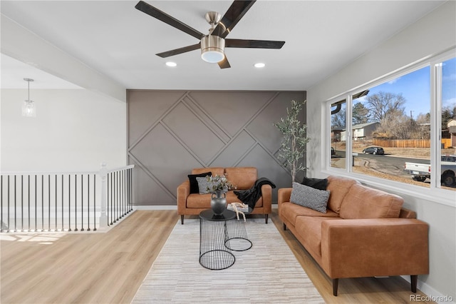 living area featuring light hardwood / wood-style floors and ceiling fan