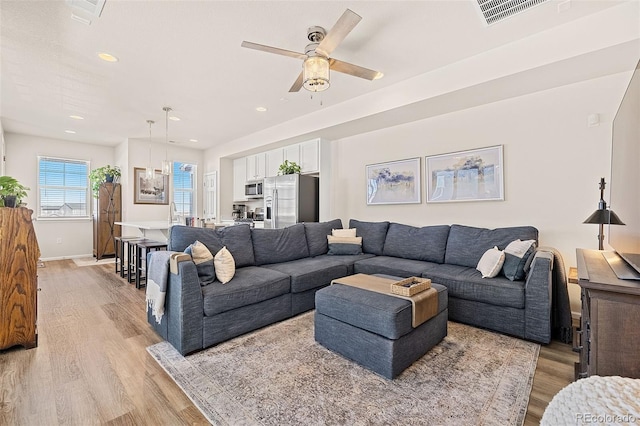 living room featuring ceiling fan and light wood-type flooring