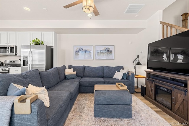 living room with light hardwood / wood-style floors and ceiling fan