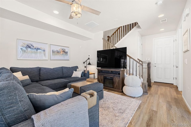 living room featuring ceiling fan and light hardwood / wood-style floors