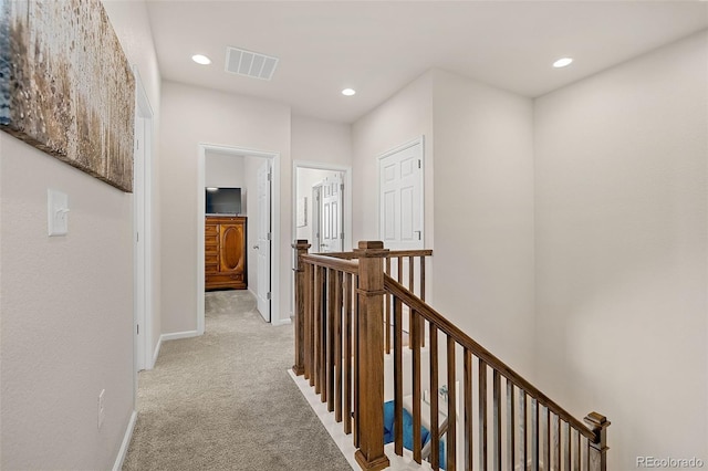 hallway featuring light colored carpet