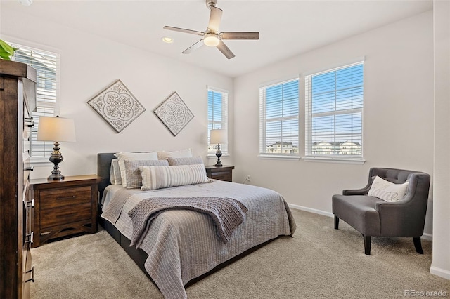 bedroom with multiple windows, light colored carpet, and ceiling fan