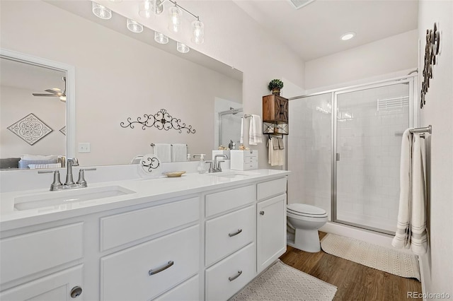 bathroom featuring vanity, hardwood / wood-style floors, a shower with door, and ceiling fan