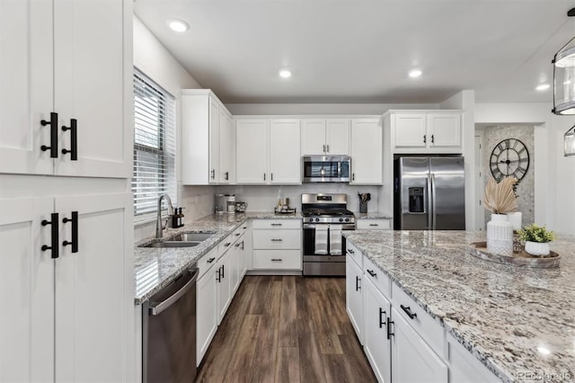 kitchen featuring dark wood finished floors, appliances with stainless steel finishes, white cabinets, and a sink