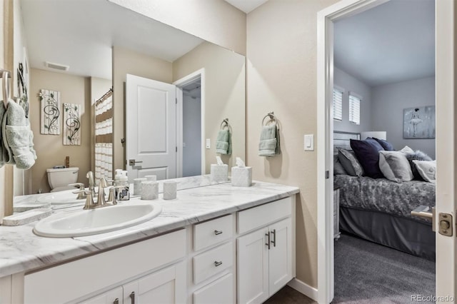 full bath featuring toilet, vanity, visible vents, baseboards, and ensuite bath