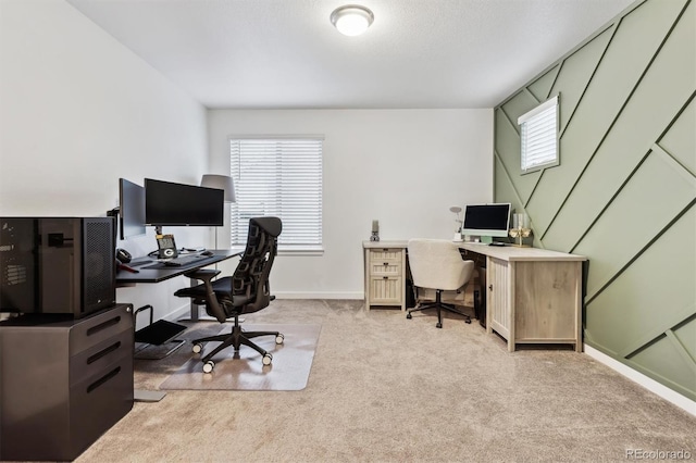 office space with baseboards and light colored carpet