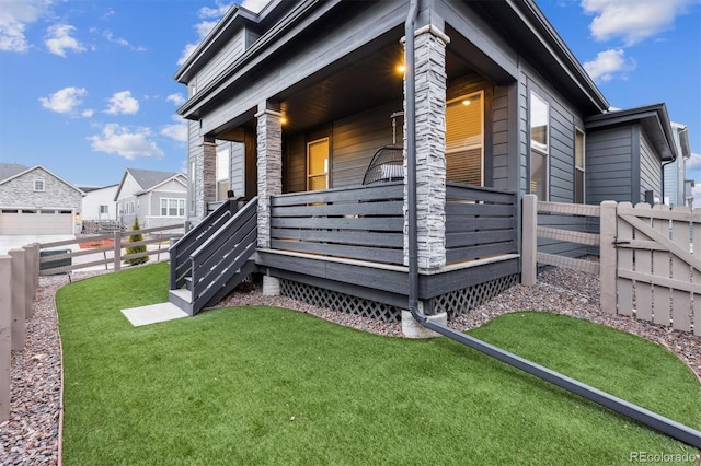 view of side of property with a yard, a porch, and fence