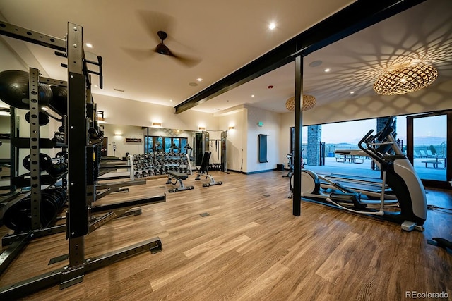 workout area with wood finished floors, a ceiling fan, and baseboards